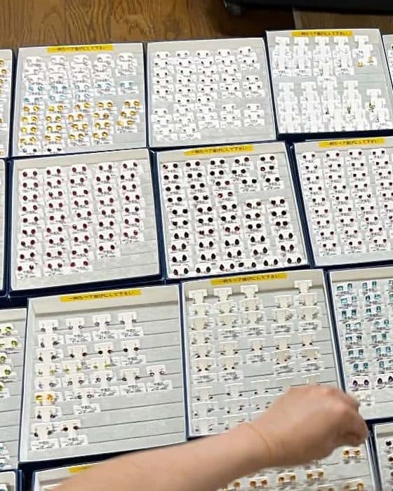 天然石ピアスのトレイを手作業で仕分けする様子
